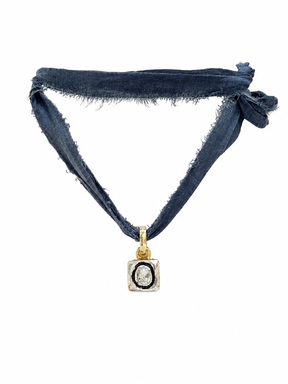 A dark blue fabric headband with frayed edges and a knotted side, featuring a gold pendant with a black oval center and a clear stone, shown on a plain white background.